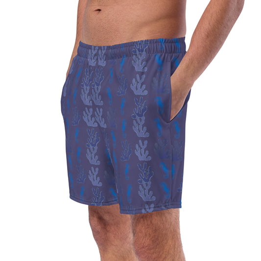 left front view of model wearing coral reef seahorse swim trunks in purple blue