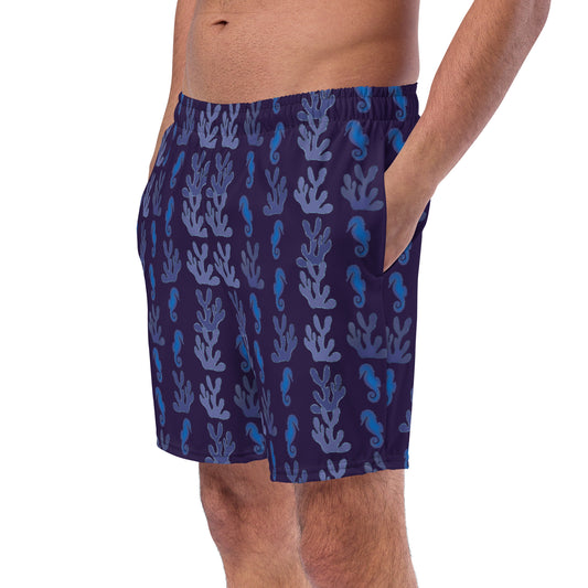 left front view of model wearing coral reef seahorse swim trunks in purple