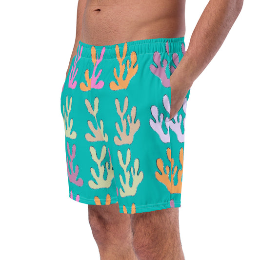 front view of model wearing coral reef swim trunks in turquoise