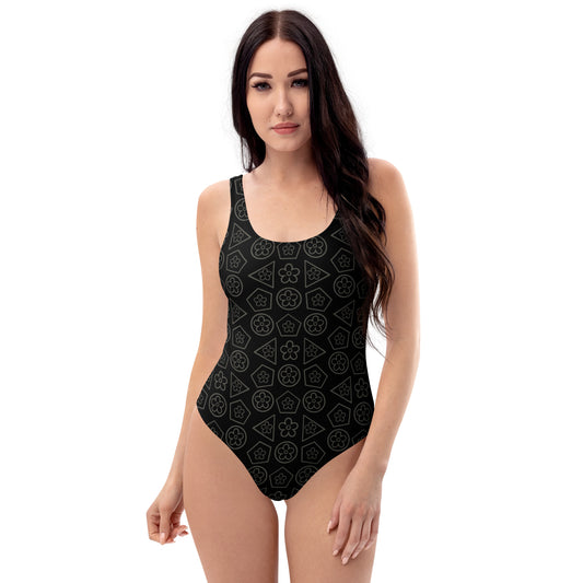 front view of model wearing black floral geometric pattern one-piece swimsuit 