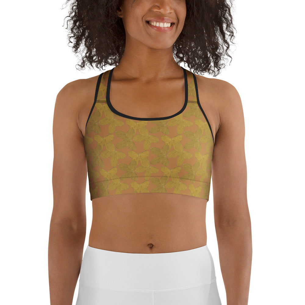  front view of model wearing gold butterfly sports bra on rose