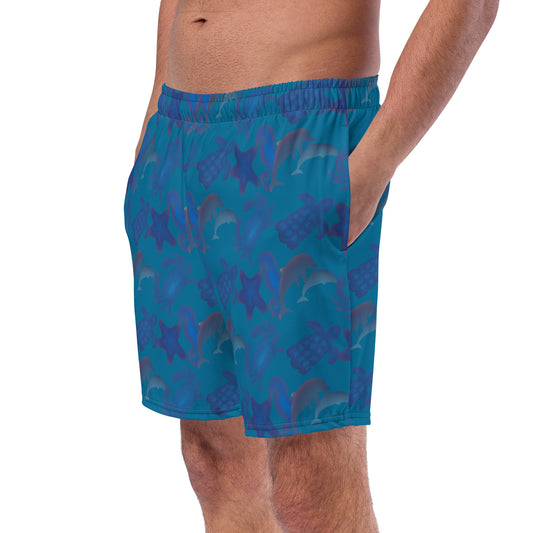 left front view of model wearing seascape swim trunks in blue green